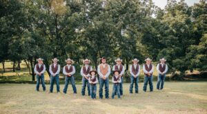 Hollow Hill Event Center Wedding and Event Venue, Weatherford, Texas. Groom with groom men standing in clearing among trees
