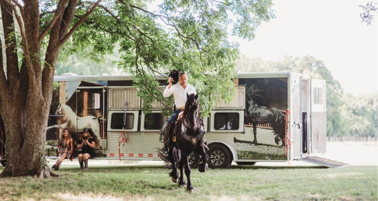 Hollow Hill Event Center Wedding and Event Venue, Weatherford, Texas. Man riding horse from horse trailer in clearing